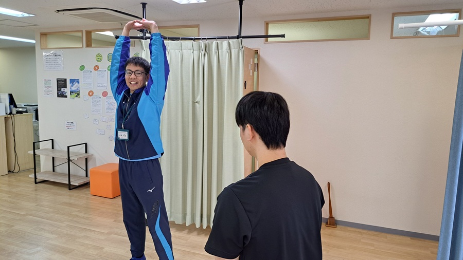 両腕を上げる姿勢をとる男性