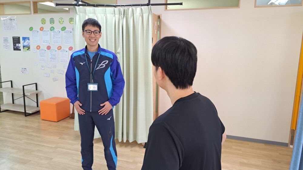 トレーナーが笑顔で話を聞いている様子